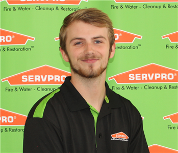 man in front of SERVPRO banner